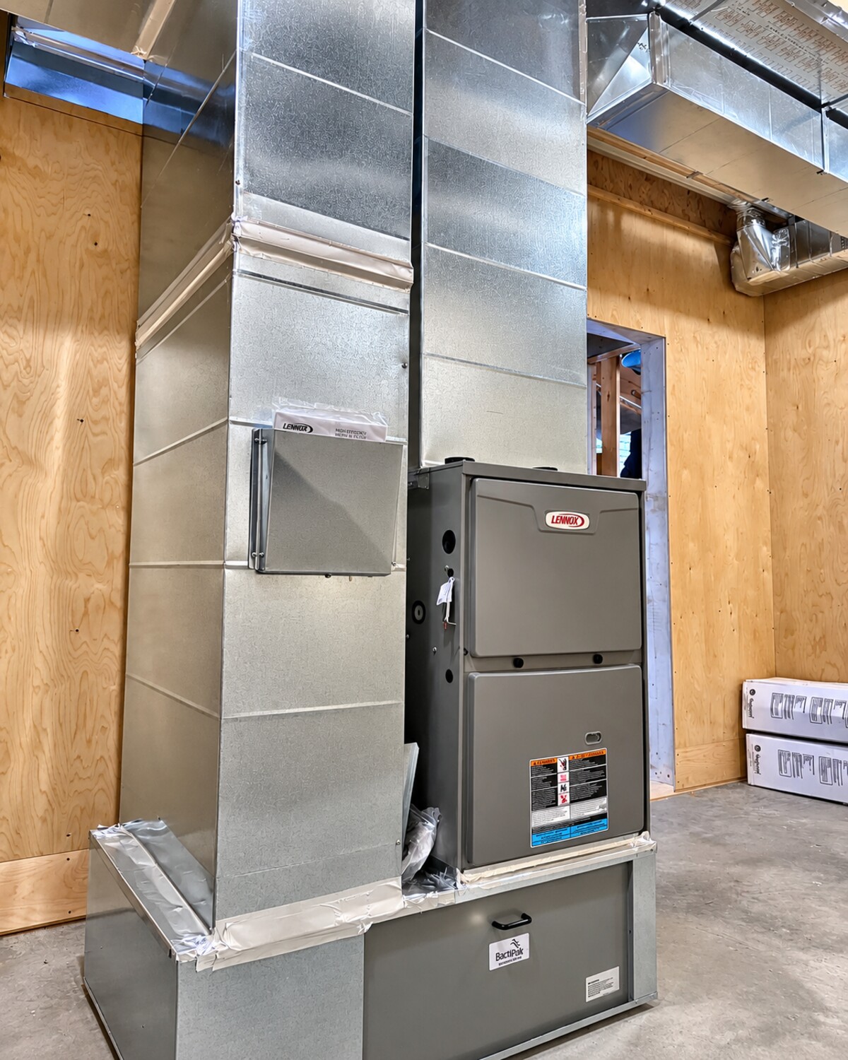 New furnace and duct plenum installed in a framed mechanical room