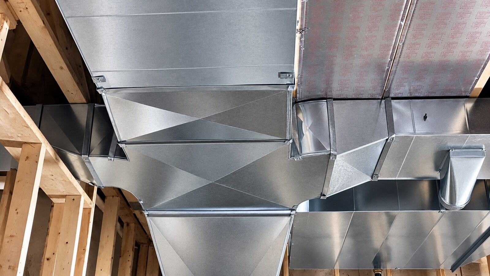 Sheet metal ductwork installed through floor trusses during rough-in