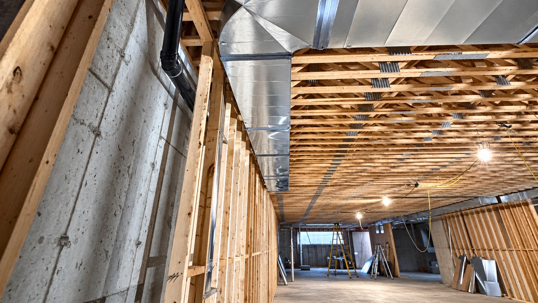Supply and return ductwork installed below floor framing during new construction